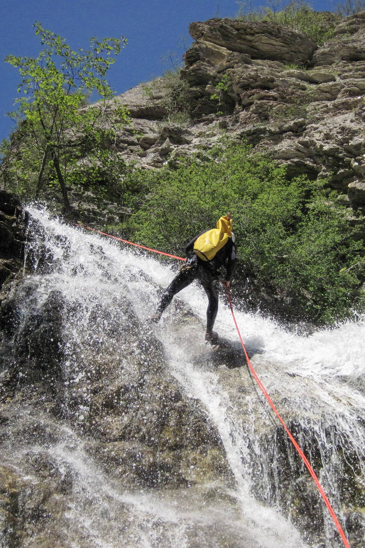 Abseilen tijdens canyoning bij waterval in Franse Alpen