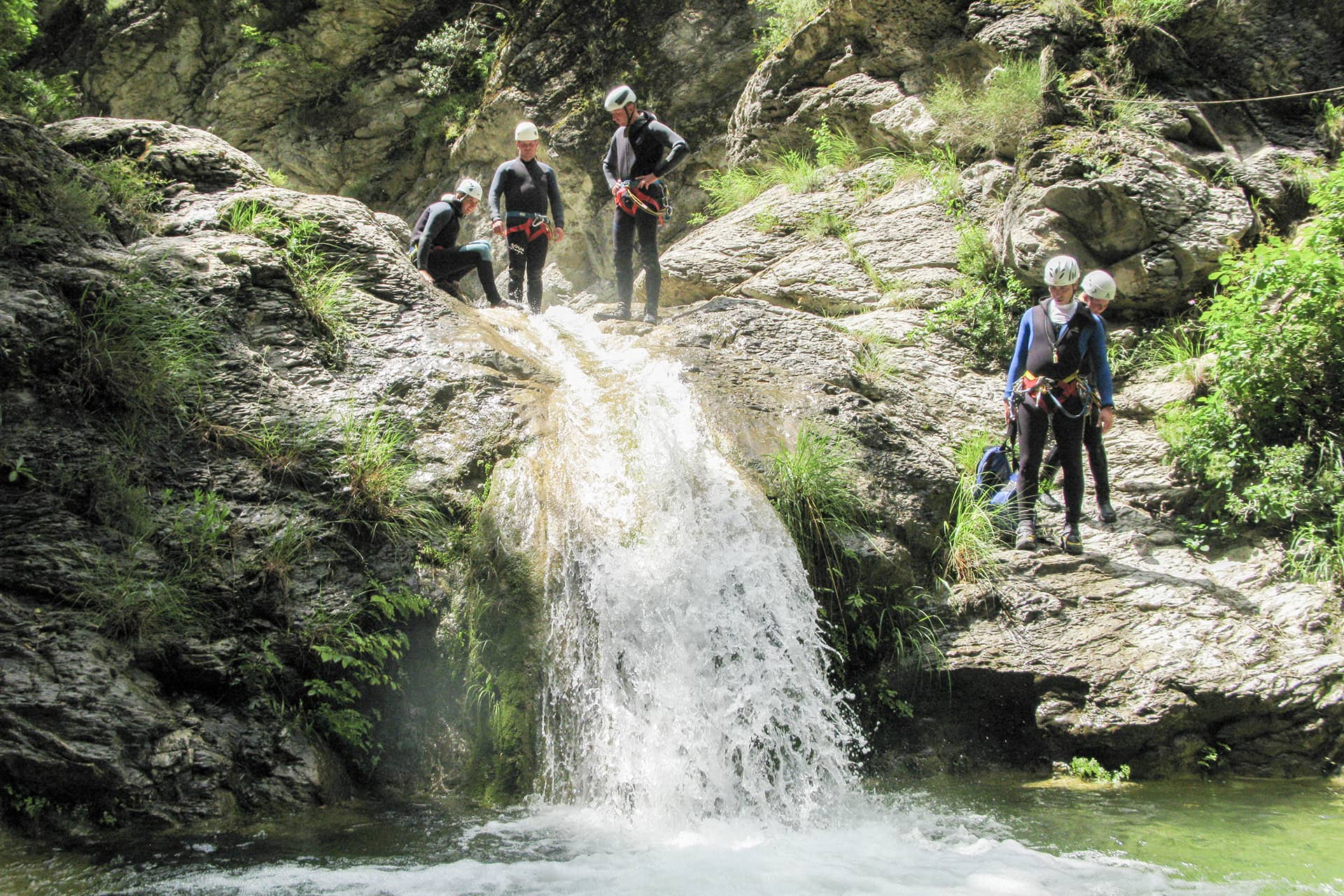 Groep tijdens canyoning bij een waterval in de Franse Alpen